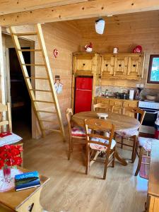 una cucina e una sala da pranzo con tavolo e sedie di Chalet des Moineaux a Saint-Laurent-du-Jura