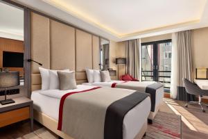 バルケスィルにあるRamada Residences by Wyndham Balikesirのベッド2台とバルコニーが備わるホテルルームです。