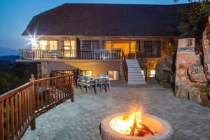 ein Haus mit einer Feuerstelle davor in der Unterkunft Blyde Canyon, A Forever Resort in Matibidi