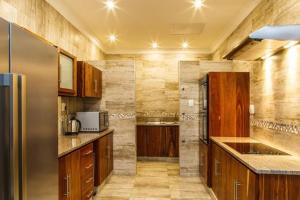 uma cozinha com armários de madeira e um frigorífico de aço inoxidável em Blyde Canyon, A Forever Resort em Matibidi