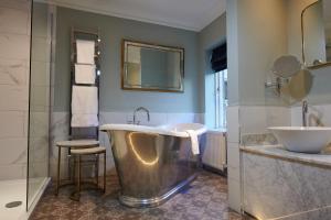 a bathroom with a large tub and a sink at The Devonshire Arms Hotel & Spa - Skipton in Bolton Abbey