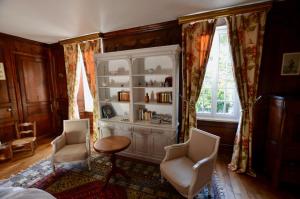 a room with a cabinet and two chairs and a table at Maison de Benedicte in Saint-Brieuc