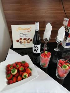 una mesa con un plato de fresas y una botella de vino en Britannia Study Hotel, en Brighton & Hove