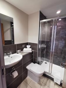 a bathroom with a toilet and a shower and a sink at Britannia Study Hotel in Brighton & Hove