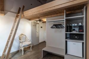 a loft bed with a ladder in a room at Stay COOPER l Goethe Guesthouse in Bolzano