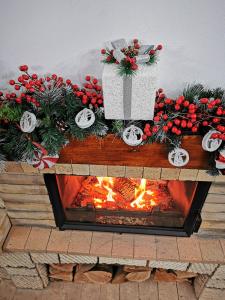 a table with a fireplace with a christmas display at Pension Sf Nicolae in Aluniş