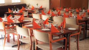 un comedor con mesas con servilletas de papel rojo. en Hotel Varmahlíd, en Varmahlid