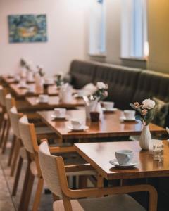 a row of wooden tables and chairs with flowers on them at Hotel Varmahl&iacute;d in Varmahlid