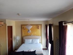 Postel nebo postele na pokoji v ubytování Kim Suites - Mvuli Studio Apartment