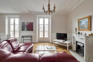 sala de estar con sofá y chimenea en Les Trois Rois - Duplex Familial de Charme en cœur de ville en Rennes