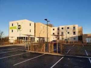 a parking lot in front of a building at B&B HOTEL Ouistreham in Ouistreham