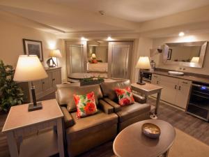 a living room with a couch and a kitchen at 1000 Islands Harbor Hotel in Clayton