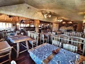 a restaurant with tables and chairs in a room at Apartman Trebević Dolina mira in Pale