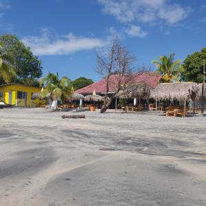 普拉亞布蘭卡的住宿－NICO'S BEACH PANAMA，海滩上设有桌子和草伞