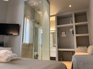 a bedroom with a shower and a bed with a mirror at Le Stanze di Corteinfiore in Trani