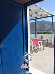 a blue door of a patio with a table and chairs at Ellibay in Livadia