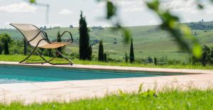 une chaise assise à côté de la piscine dans l'établissement I Sodi di Bibbiano, à Lilliano