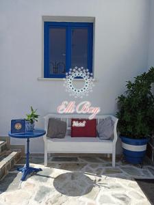 un panneau indiquant toute la journée sur un mur blanc avec un canapé dans l'établissement Ellibay, à Livadia