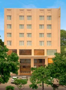 a large tan building with cars parked in front of it at Bloom Boutique l Ranjit Avenue in Amritsar