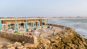 a building on the beach next to the ocean at Westpoint Dakhla in Dakhla