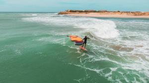 a person on a surfboard in the ocean at Westpoint Dakhla in Dakhla