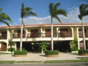 a building with palm trees in front of it at Green Paradise in Juan Dolio