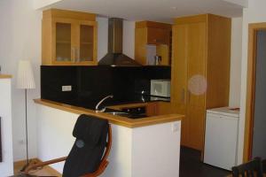 a kitchen with a sink and a counter with a chair at Valencia de Aneu TP in Valencia de Aneu