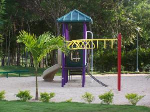 een speeltuin met een glijbaan in een park bij Green Paradise in Juan Dolio