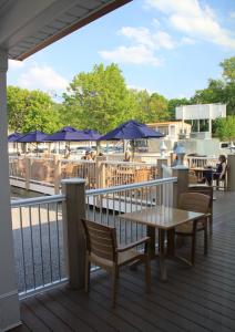 een terras met een tafel, stoelen en parasols bij Lake Front Hotel in Cooperstown