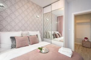 - une chambre avec un grand lit et un miroir dans l'établissement Angel Apartments 2, à Cracovie