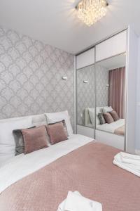 - une chambre avec 2 lits et un grand miroir dans l'établissement Angel Apartments 2, à Cracovie