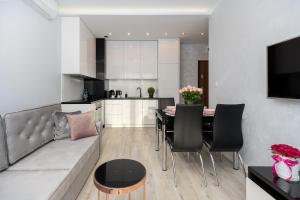 a living room and kitchen with a couch and a table at Angel Apartments 2 in Krakow
