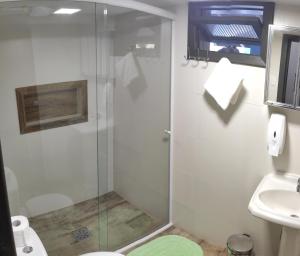 a bathroom with a shower and a toilet and a sink at Barra Beach Club CASAS in Florianópolis
