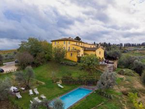 a large yellow house on a hill with a swimming pool at Poderi in Chianti in Tavarnelle in Val di Pesa