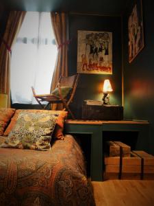 ein Schlafzimmer mit einem Bett und einem Schreibtisch mit einer Lampe in der Unterkunft La Galerie-gîte in Metz