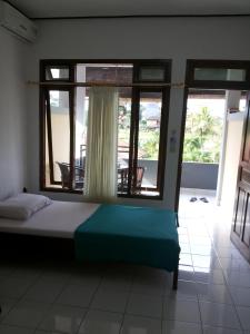 a bedroom with a bed and a large window at Raditia Homestay in Ubud