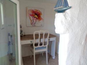 オストゥーニにあるOne bedroom house with sea view furnished terrace and wifi at Ostuni 5 km away from the beachのデスク、椅子2脚、ランプが備わる客室です。