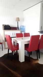 a white table and red chairs in a room at 3 bedrooms appartement with sea view furnished terrace and wifi at Nigran in Nigrán