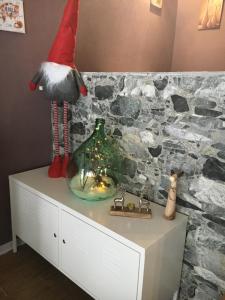 un gnome assis au-dessus d'un cabinet avec un vase dans l'établissement Sul cucuzzolo, à Marilleva