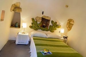 1 dormitorio con 1 cama con cactus en la pared en One bedroom house with private pool and furnished garden at Ceglie Messapica, en Ceglie Messapica