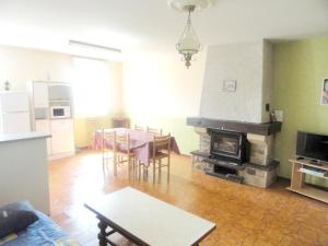 uma sala de estar com uma mesa e uma lareira em Maison de 2 chambres avec jardin clos a Saint Laurent la Roche em Saint-Laurent-la-Roche
