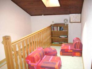 uma sala de estar com duas cadeiras e uma estante de livros em Maison de 2 chambres avec jardin clos a Saint Laurent la Roche em Saint-Laurent-la-Roche