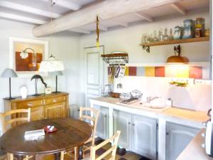 a kitchen with a table and a sink and a counter at Maison charmante à Oppède avec vue sur la montagne in Oppède