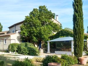 a house with a tree in front of it at Maison charmante à Oppède avec vue sur la montagne in Oppède