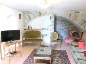 ein Wohnzimmer mit einem Sofa, Stühlen und einem TV in der Unterkunft Maison de 4 chambres avec jardin amenage et wifi a Saint Andre en Vivarais in Saint-André-en-Vivarais