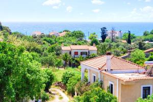 a house on a hill with the ocean in the background at 5 bedrooms villa at Limnos 250 m away from the beach with sea view enclosed garden and wifi in Lemnos