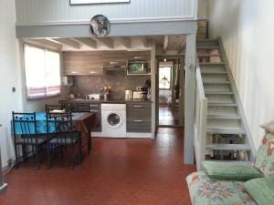 a kitchen and dining room with a staircase in a house at Tres agreable maison au calme dans la pinede in Lacanau-Océan