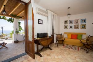 een woonkamer met een bureau en een bank bij 2 bedrooms house at Lipari 300 m away from the beach with sea view furnished terrace and wifi in Lipari