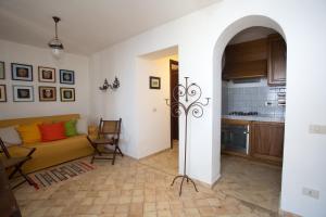 een woonkamer met een bank en een keuken bij 2 bedrooms house at Lipari 300 m away from the beach with sea view furnished terrace and wifi in Lipari