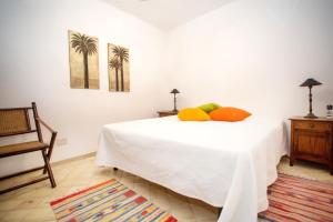 een slaapkamer met een wit bed met 2 kussens erop bij 2 bedrooms house at Lipari 300 m away from the beach with sea view furnished terrace and wifi in Lipari